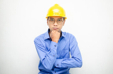 Asian construction worker in blue shirt and yellow safety helmet is seriously thinking with a wondering and thinking gesture and expression.