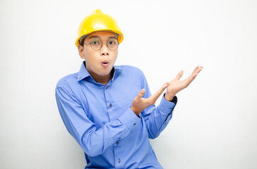 asian construction worker wearing yellow safety helmet shouting with shocked and surprised expression.