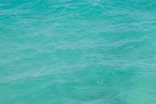 Aguas turquesas en una playa de arenas blancas. Superficie rizada del agua del mar observada desde lo alto de un acantilado en Torre dell'Orso, Puglia, Italia.
