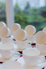 set of white tea cups on red tablecloth