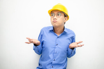 Young Asian man construction worker in yellow safety helmet unsure of what to choose with hand pointing left or right, isolated over whote background. advertising model for billboards.