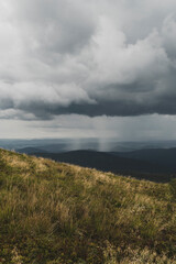 Widok w Bieszczadach z Połoniny Caryńskiej. Ciemne burzowe chmury , oberwania chmury i nawałnica