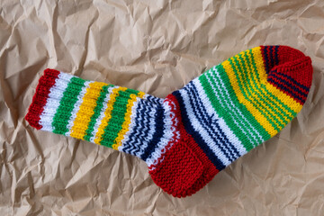 Hand knitted woolen striped socks on kraft paper background