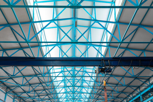 Ceiling of warehouse with metal girders with electric hoist. Metal beams in industrial production hall or warehouse. Moving heavy loads