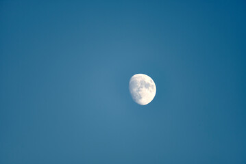 An almost full moon on a blue background