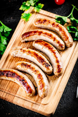 Aromatic grilled sausages on a cutting board. 