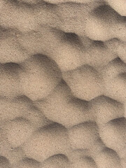 Fine yellow sand lies in a bizarre shape in the form of circles blown by the wind on a wild beach. High quality photo