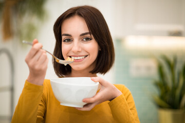 Portrait of pretty happy fit lady having oatmeal