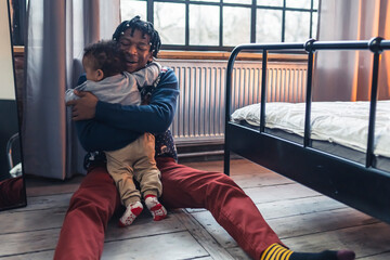 Father and his toddler son hugging on the floor. High quality photo