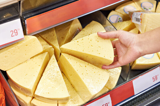 Hands with cheese in shop