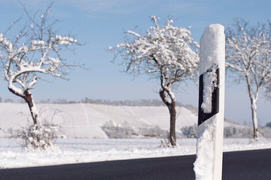 snow-covered country road bollard