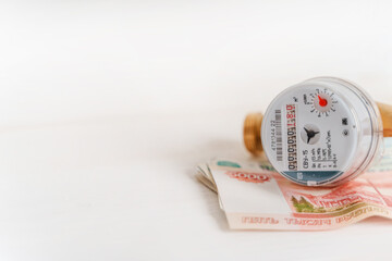 Water meter with Russian banknotes. Payment for utilities and water supply