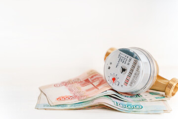 Water meter with Russian banknotes. Payment for utilities and water supply