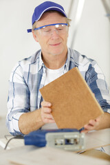 carpenter checking the sharp edges of a wood piece