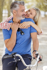couple hugging near the modern bicycle in park