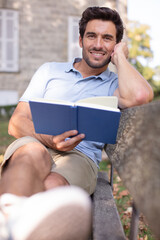 Fototapeta premium man on park bench reading a book