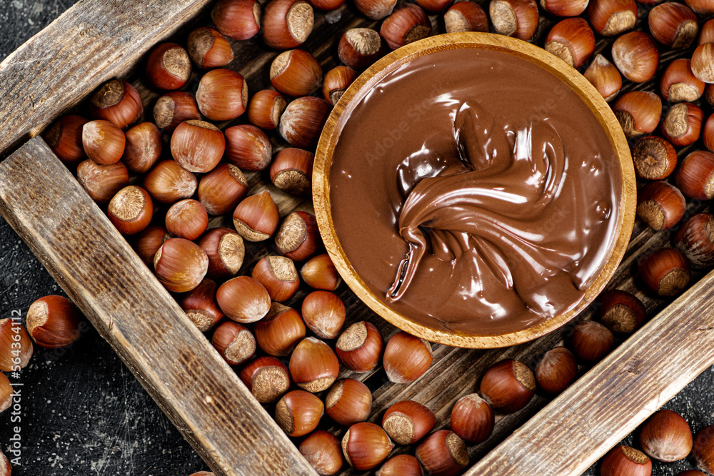 Sticker hazelnut butter on a wooden tray.