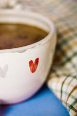 Close up white ceramic cup with a symbol of red heart and black coffee. Hot fresh morning drink beverage vertical background. Heart shaped symbol of love, affection. I like caffeine. Valentine Day.