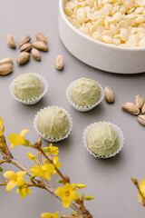 Natural healthy candies with white chocolate and pistachios. Green cheese truffles. Vertical
