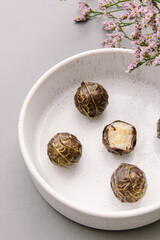 Set of natural healthy chocolate candies on plate. Vegan sweets. Bitten candy