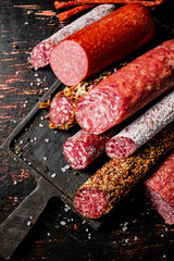 Different types of salami sausage on a cutting board. 
