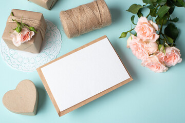 Close-up of a kraft envelope on the background of a gift and a bouquet of bush roses.