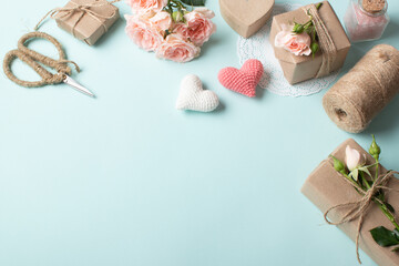 Composition for Valentine's Day of gifts in eco-packaging, natural flowers on a light blue background.