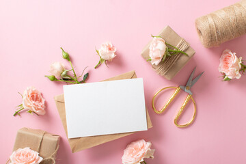 A Valentine's Day composition of eco-packaged gifts, a kraft envelope and fresh flowers on a light pink background. Vintage banner.