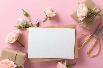 Obraz na płótnie Canvas A Valentine's Day composition of eco-packaged gifts, a kraft envelope and fresh flowers on a light pink background. Vintage banner.