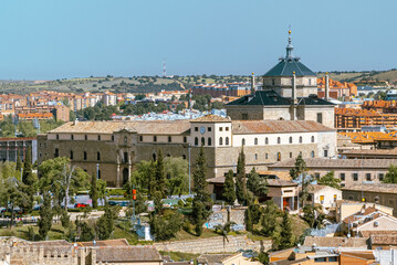 Toledo, España. April 29, 2022: Tavera Hospital and panoramic landscape with blue sky. - obrazy, fototapety, plakaty