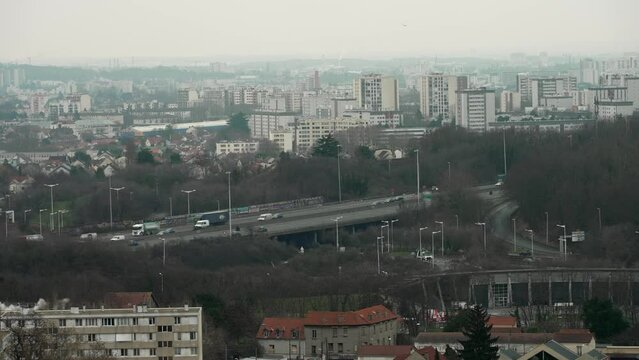 Panorama sur une grande ville et une autoroute avec du trafic routier par temps nuageux en hiver