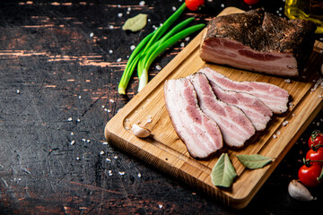 Pieces of homemade pork fat with green onions and cherry tomatoes. 