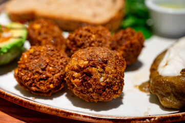 Healthy vegetarian food, vegan falafel balls served with grilles baked eggplant and grilled avocado