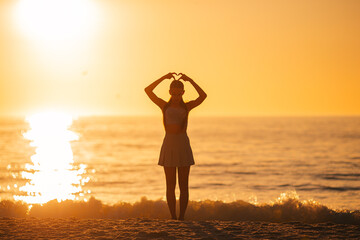 Happy teen girl enjoy tropical beach vacation at sunset