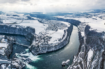 Panorama aerial image of the Rheinfall waterfall in snow-covered winter landscape