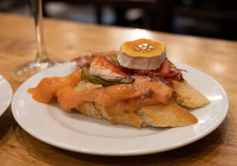 Board with typical snacks of Basque Country, pinchos or pinxtos, skewers or small piece of bread with toppings, served in bar in San-Sebastian or Bilbao, Spain