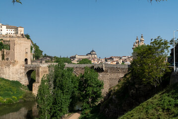 Fototapeta na wymiar Toledo, España. April 29, 2022:Alcantara Roman Bridge with landscape and blue sky.