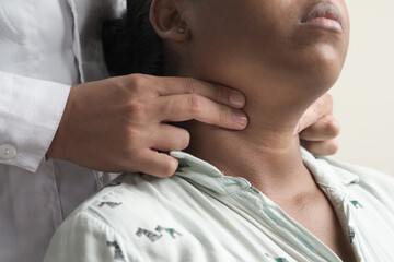 unrecognizable doctor's hands palpating carotid pulse female patient