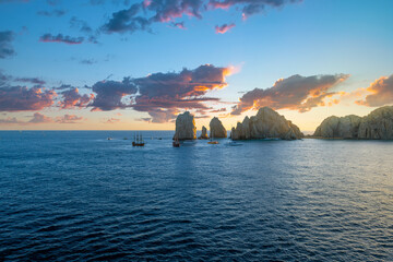 Colorful clouds at sunset above the sea and El Arco coastal rocks at the Mexican resort town of Cabo San Lucas, Mexico.