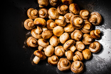 Small fried mushrooms in a frying pan. 