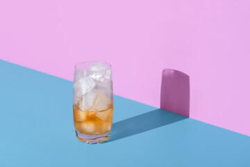 Ice tea glass, half empty, minimalist on a vibrant colored background