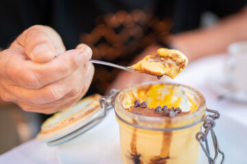 Traditional Italian Dessert In a Glass Jar. Tiramisu on a spoon.


Traditional Italian Dessert In a Glass Jar. Tiramisu on a spoon.