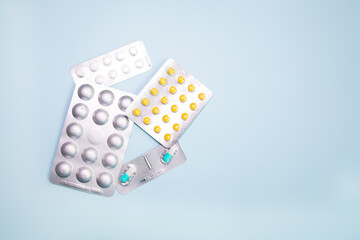 Supplements and pills blister packs, close-up. Place to insert your text, blue background. Pharmacists and clinics. 