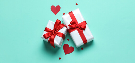 Gift boxes for Valentine's Day and hearts on color background, top view