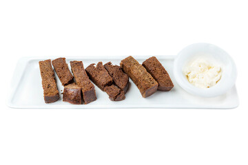 Black bread croutons with sauce in a white snack plate. Appetizing popular snack for beer. Close-up. Top view. Isolated on white background.