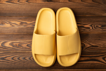 Rubber summer slippers. Replacement shoes for home or office. Yellow slippers on a background of...