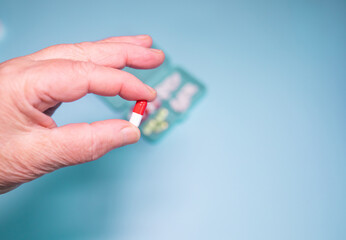 Close up mature senior woman taking pill. Elderly healthcare and treatment concept.