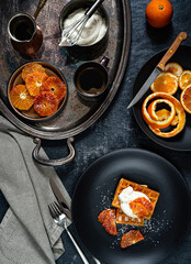 Belgian waffles with oranges and wippet cream. Served on a silver antique tray. Top view. Photo in rustic style.
