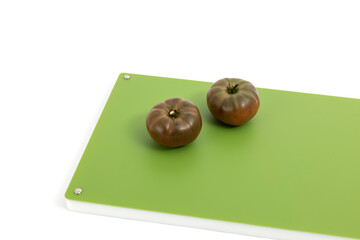 Vegetables on green professional chopper - black tomatoes