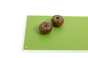 Vegetables on green professional chopper - black tomatoes